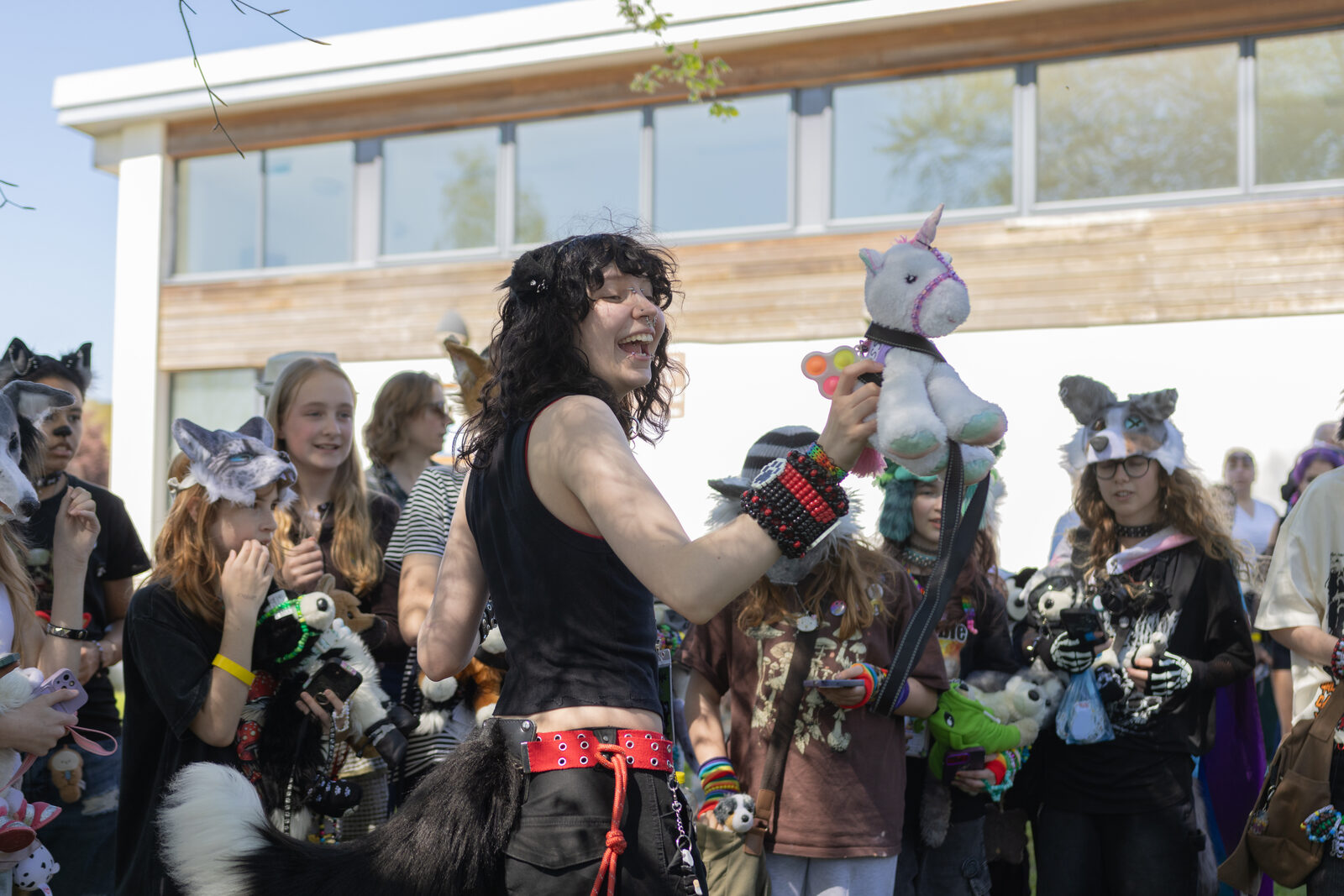 An attendee laughing with a unicorn plush at Pups in the Park